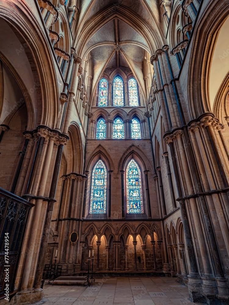 Naklejka premium Lincoln Cathedral, Roman Catholic Gothic church and cathedral with stain glass window corridor and hall, with arches, columns, pews, vault, aisles, gallery, arcades and clerestory.