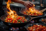 A chef is cooking food in a pan with a lot of fire