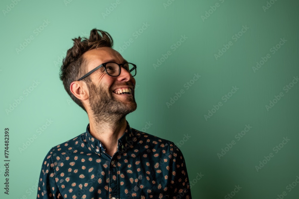 Handsome man with glasses laughing against a turquoise background Handsome man with glasses laughing against a turquoise background