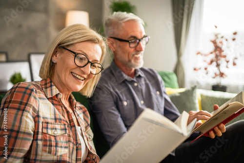 mature senior couple man and woman husband and wife read book at home