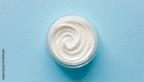 White cosmetic cream lotion moisturizer strokes on pastel blue. Hygiene, skincare product creamy texture. Beauty face creme smear smudge swatch on color background photo