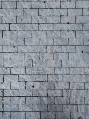 Worn and stained old gray brick wall creating a grunge background texture.