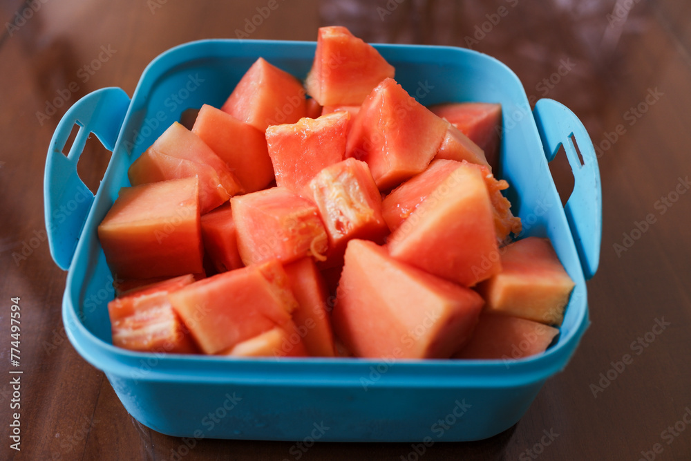 Ripe red papaya fruit that has been cut, in a purple box, on the table, stock photo. Ripe red papaya fruit that has been cut, in a purple box, on the table, stock photo.