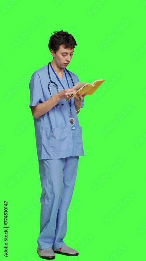 Side view Medical assistant reading a literature book against greenscreen backdrop, enjoying healthcare industry lecture to acquire new expertise. Nurse paying attention to medicine manual at work Side view Medical assistant reading a literature book against greenscreen backdrop, enjoying healthcare industry lecture to acquire new expertise. Nurse paying attention to medicine manual at work