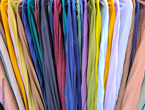 collection of colorful Vibrant fabric of clothes hanging on clothes hanger in closet or clothing rack. background of colorful clothes