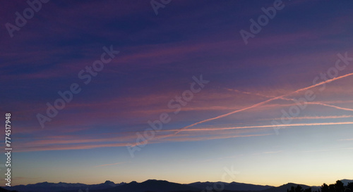 Tramonto luminoso rosso e azzurro nello spazio immenso del cielo sopra la catena dei monti Appennini photo