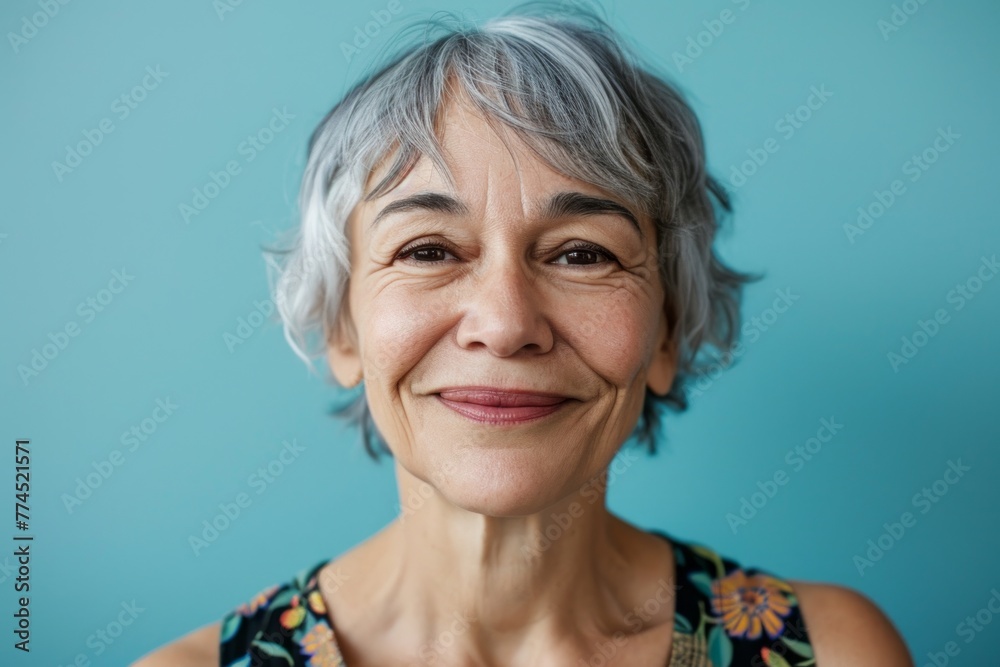 Portrait of a smiling senior woman with grey hair on a blue background Portrait of a smiling senior woman with grey hair on a blue background