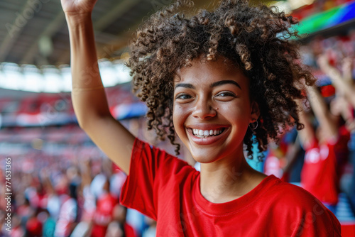 Bantu African woman in red t-shirt happily raises fist in victory photo