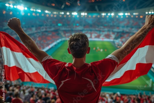 A man is holding a red and white flag in a stadium full of people. Football fan supporting the team