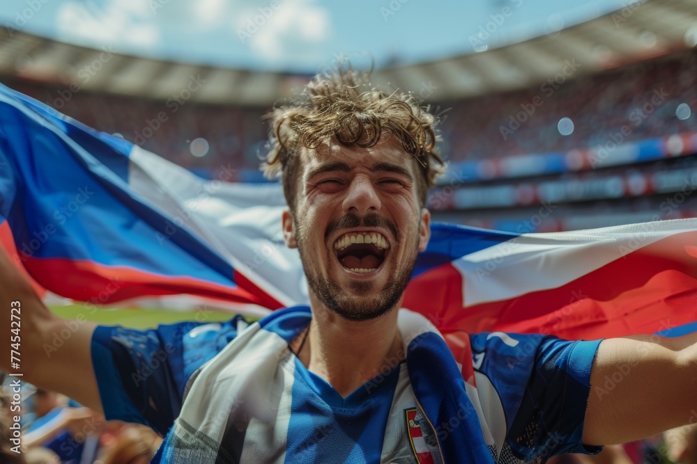 A man is holding a flag and smiling. Football fans at the European Football Cup A man is holding a flag and smiling. Football fans at the European Football Cup