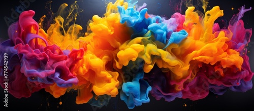 Vibrant liquid paint of various colors is slowly being swirled and mixed into clear water creating fascinating patterns
