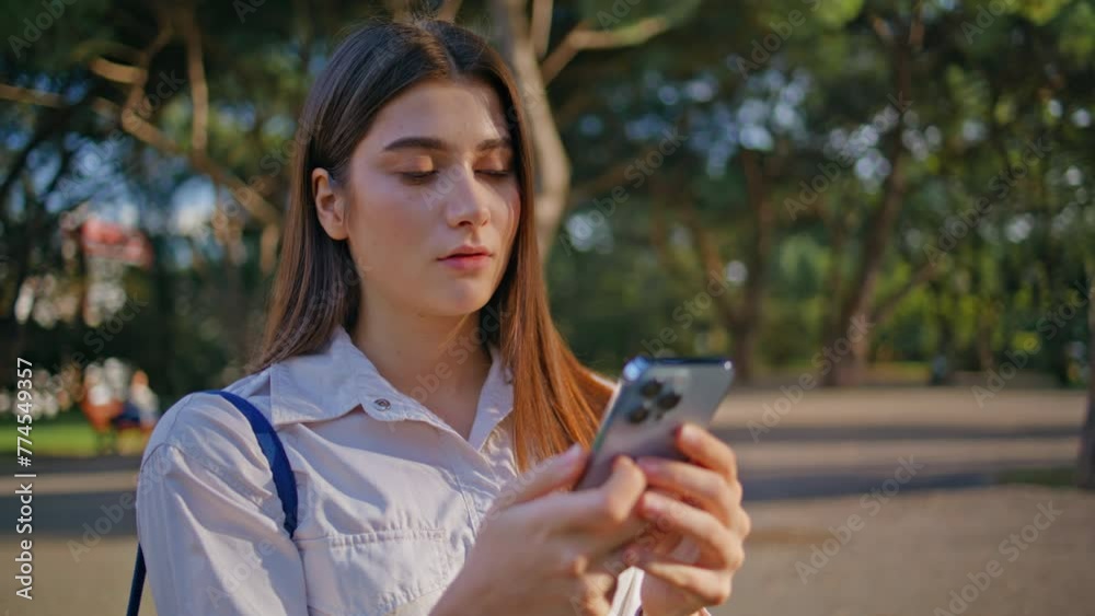 Pensive lady typing smartphone in sunny park closeup. Thoughtful woman messaging Pensive lady typing smartphone in sunny park closeup. Thoughtful woman messaging