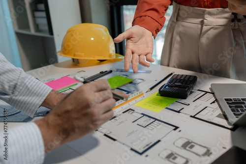 An engineer works with an architect to study the specifics of construction blueprints and use various tools to find the information, Compasses and rulers for design work