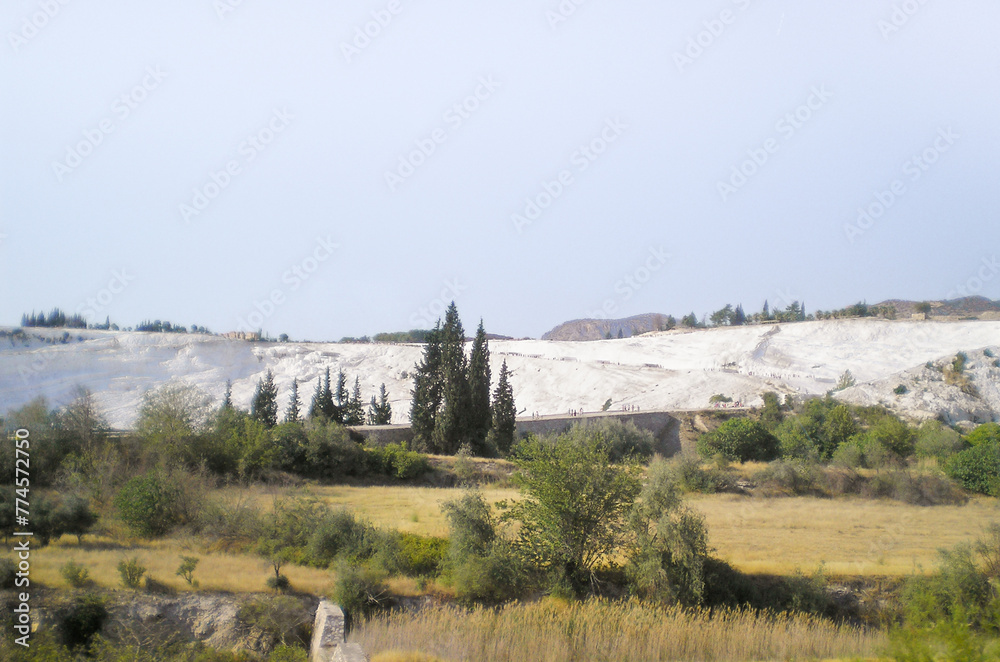 Fototapeta premium The indescribable beauty of Pamukkale thermal springs with cascading terraced baths decorated with snow white calcite stalactites in Denizli province in southwestern Turkey