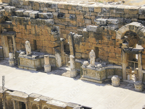 Stone ruins of an amphitheater scene with stone statues in Hierapolis one of the largest ancient cities in Turkey #774572935