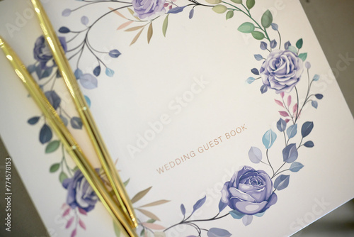 Delicate floral wedding guest book with golden pens photo