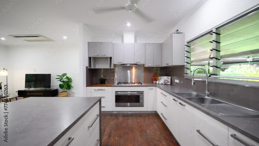 Modern Luxury Kitchen dolly along island with grey and stainless steel cabinets and chopping block. Interior of house home for real estate property.