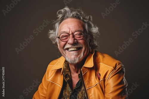 Portrait of a happy senior man in a yellow jacket and eyeglasses. © Stocknterias