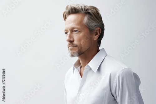 Portrait of handsome mature man in white shirt. Studio shot.