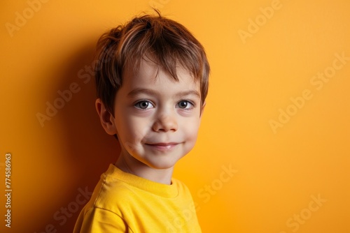 Portrait of a cute little boy in a yellow T-shirt on a yellow background