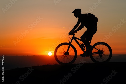 shot Silhouette of a man on mountain bike at sunset photo