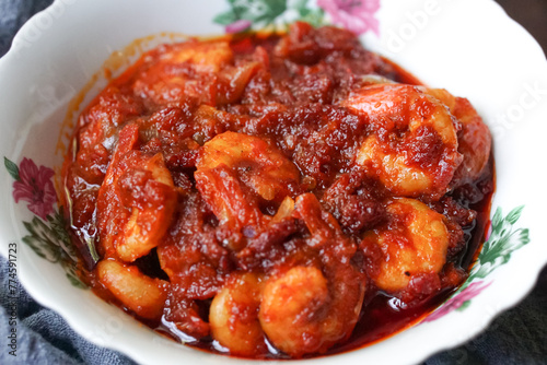 A bowl of chili prawns (sambal udang) on selective focus and blurry background.