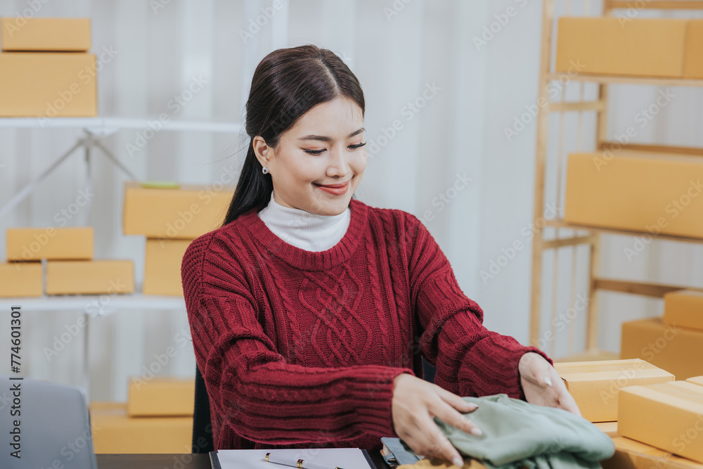 Small business entrepreneurSME Independent Asian woman using laptop with box Cheerful successful Asian woman Online marketing and SME delivery ideas Small business entrepreneurSME Independent Asian woman using laptop with box Cheerful successful Asian woman Online marketing and SME delivery ideas