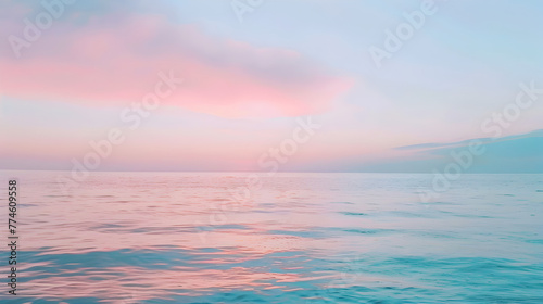 A beautiful blue ocean with a pink sky in the background. The sky is filled with clouds, giving the scene a serene and peaceful atmosphere © tracy