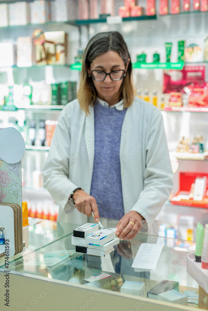 Pharmacy assistant preparing medicines for sale at a pharmacy Pharmacy assistant preparing medicines for sale at a pharmacy