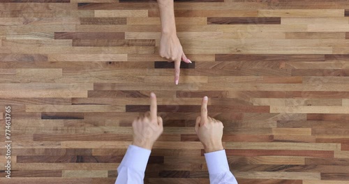 Pointing finger and discussing and arguing at a wooden table top view photo