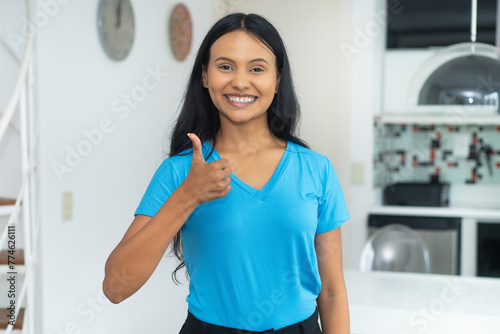 Successful young mexican woman with casual clothes showing thumb up
