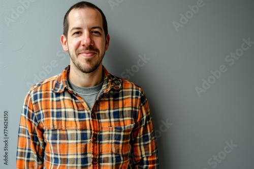 Handsome young man in a plaid shirt on grey background