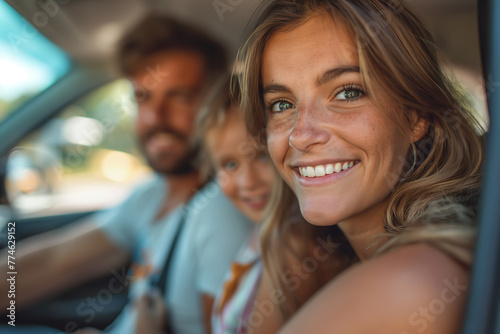 Smiling man driving a car with a woman sitting beside him, enjoying a summer journey   © VRAYVENUS