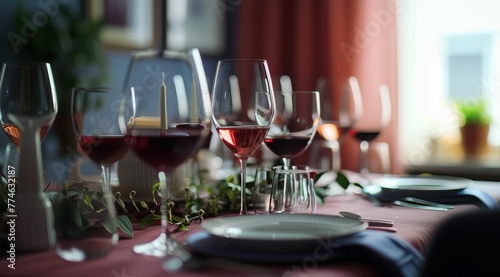  A line of wine glasses atop a table, adjacent to a plate bearing a knife and fork