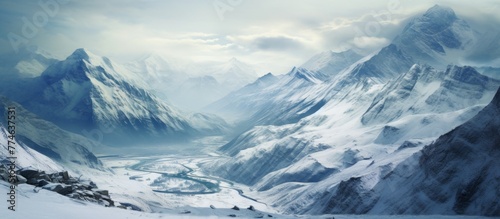 A scenic view of a river meandering through majestic mountains covered in a blanket of snow in the winter landscape