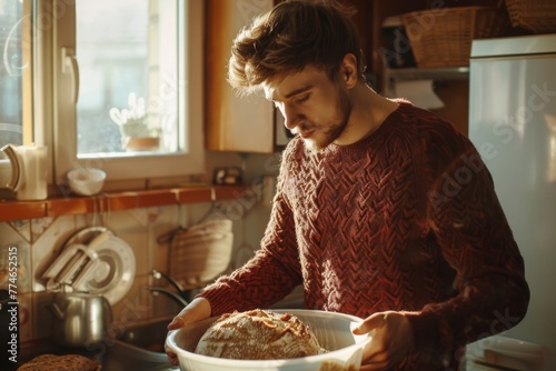 Man in a cozy kitchen enjoying the warmth of fresh bread photo