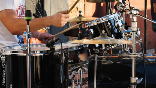 Drummer behind a drum kit. A drum set including snails, bass drum, tom-toms, cymbals and hi-hat, ready to play a rhythm.