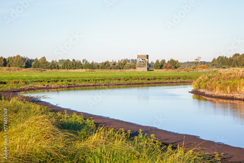 Riverbend in a wetland with a bird tower