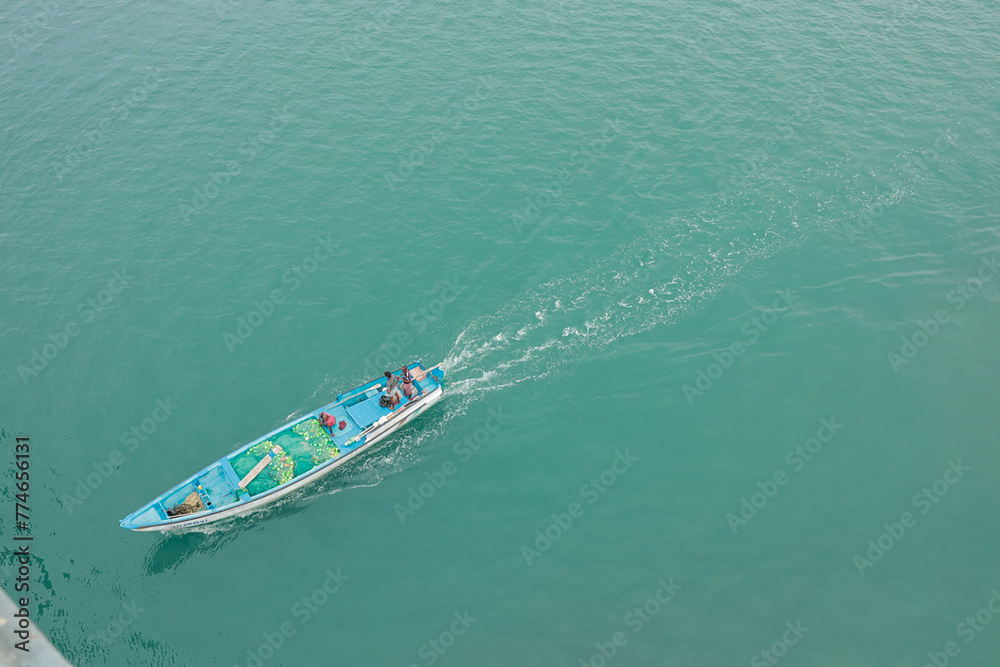 Naklejka premium Close up of a splashing boat on the ocean. Aerial view from Pamban bridge, Rameswaram