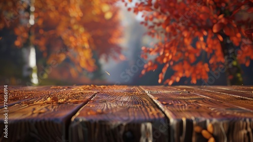 Close-up view of a wooden table surface with a blurred autumn tree in the background