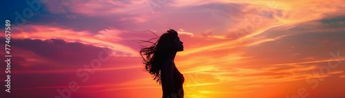 Silhouette of a woman against a stunning sunset sky  with vibrant colors painting the background