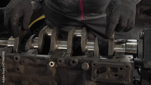 master inserts crankshaft into engine photo