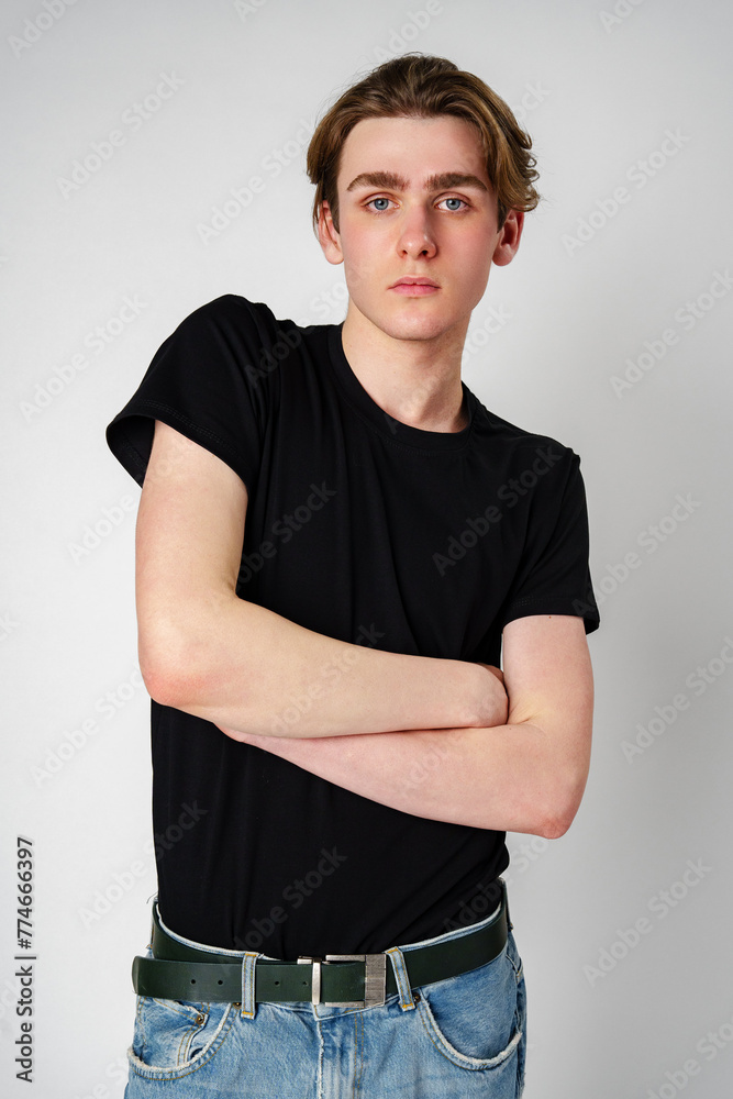 Young Man With Brown Hair Wearing Black T-Shirt Posing Against a White Background Young Man With Brown Hair Wearing Black T-Shirt Posing Against a White Background