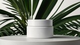 White cosmetic bottle containers on white table with palm leaves on background.