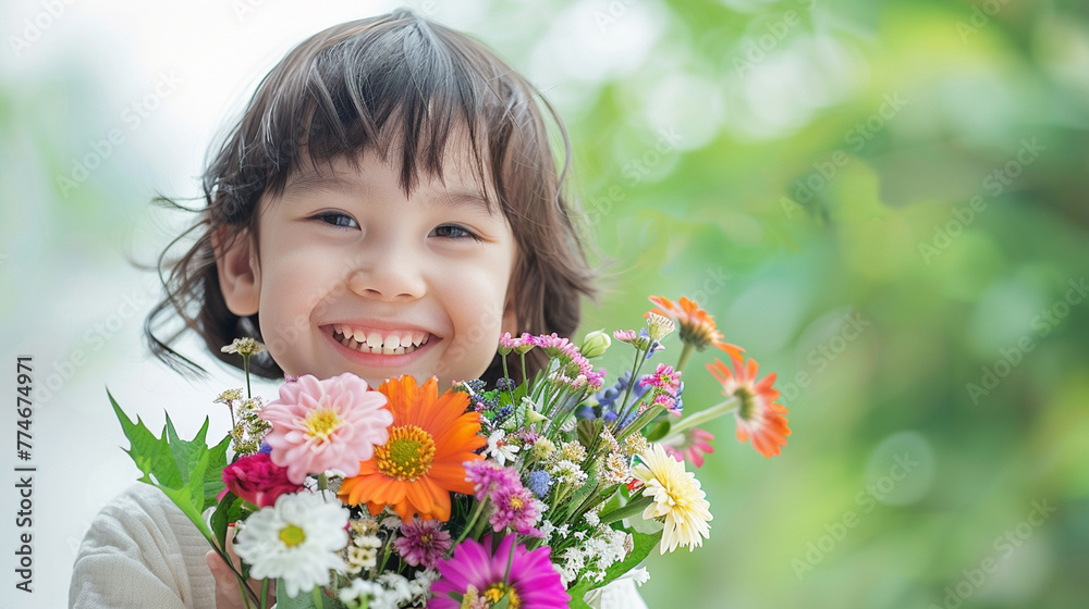Happy, smiling kid with bunch of colorful flowers for mothers day or birthday celebration. Horizontal banner or background