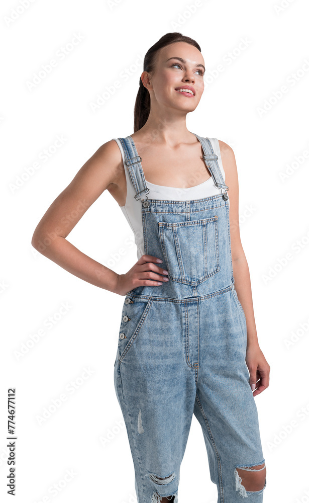 Obraz premium A young woman wearing denim overalls smiling and looking up, with a white background, studio photo