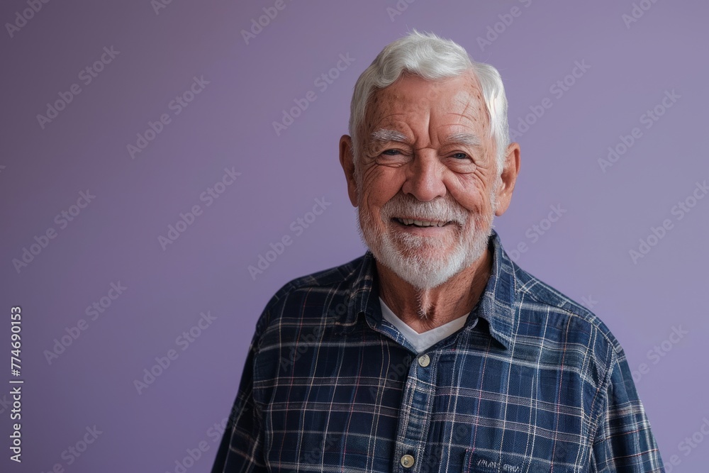 Portrait of a happy senior man smiling at the camera while standing against purple background Portrait of a happy senior man smiling at the camera while standing against purple background