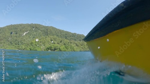 Boating At The Clear Blue River Of Kali Biru In Raja Ampat Regency, West Papua Province, Indonesia. POV low angle Shot photo