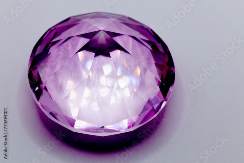 a purple diamond in glass for children to play with on light background