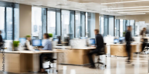 An office scene with motion blur capturing people in the background © karandaev